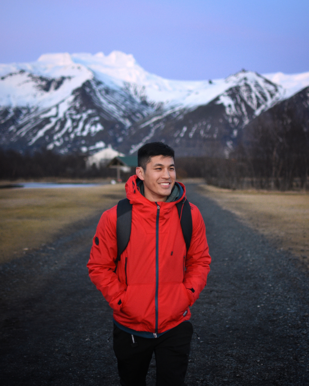 Author wearing a red jacket standing in front of a snow-capped mountain